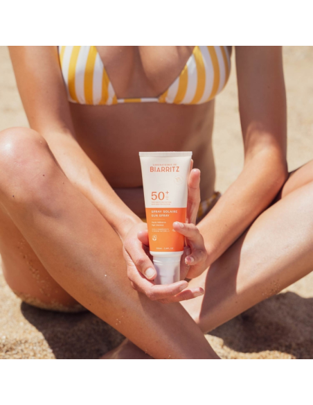 Mujer usando Spray solar cara & cuerpo SPF50+ Laboratoires de Biarritz